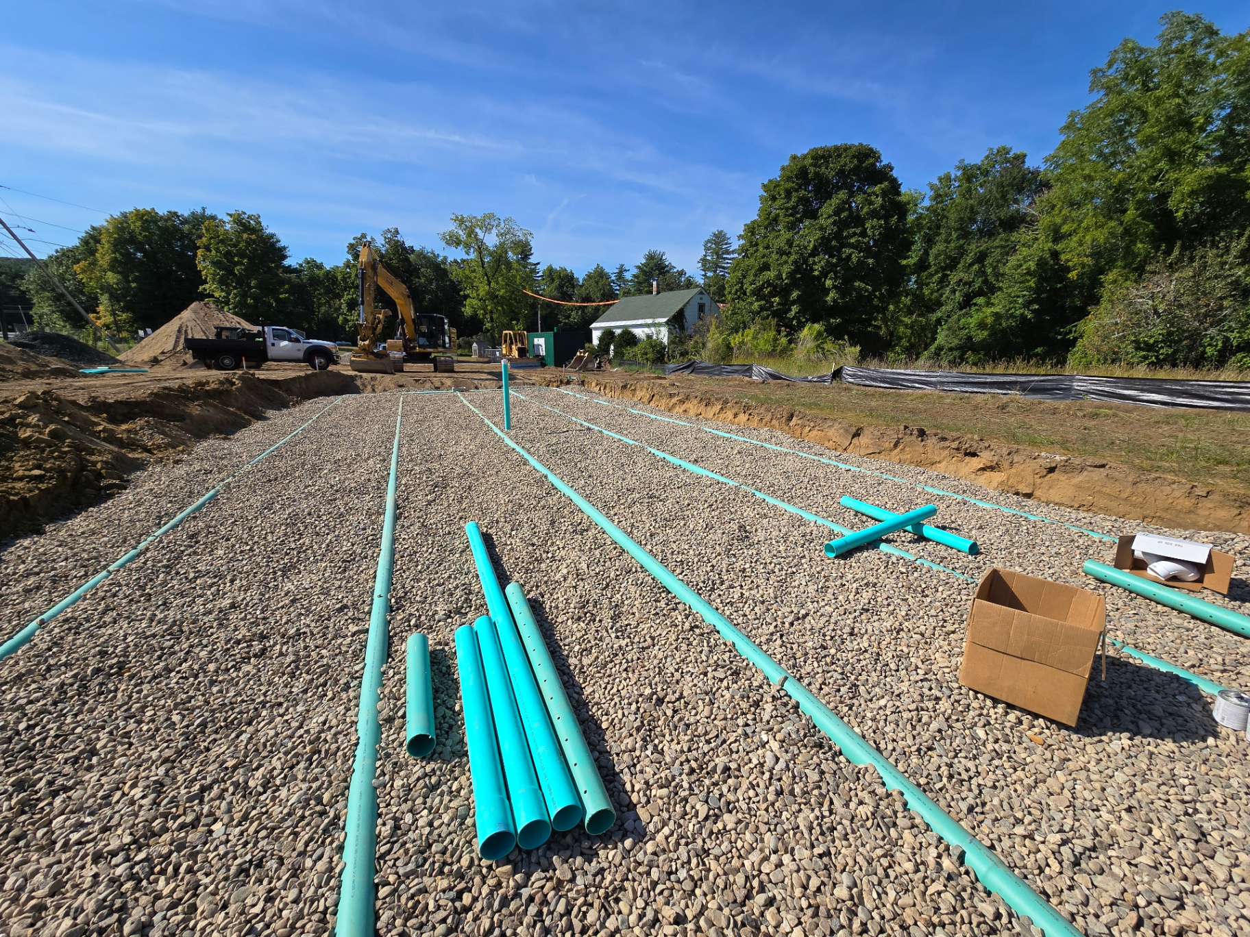 Leach field piping installed over stone bedding during septic system construction.